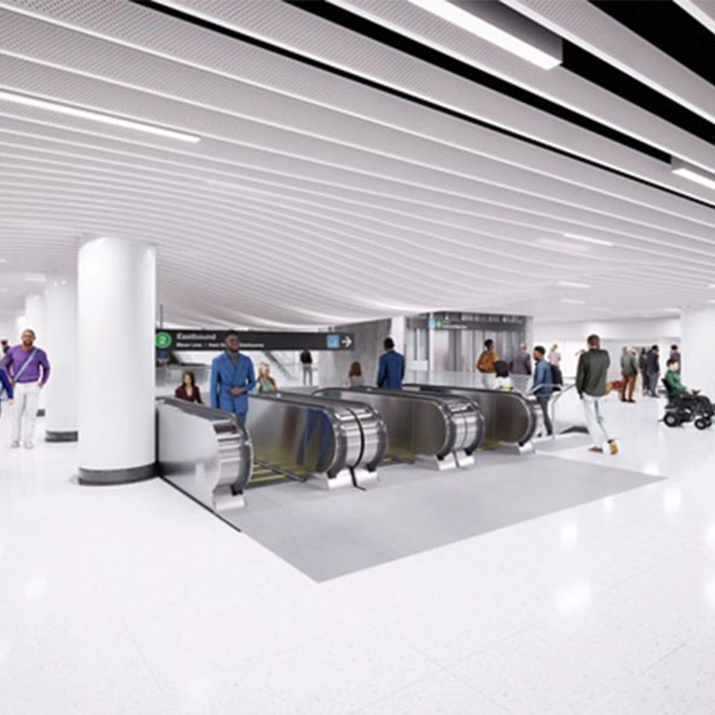 A group of people walking around Bloor Yonge station with escalators in center