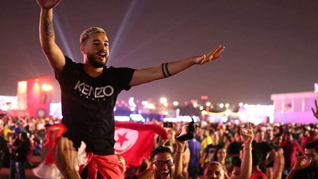 A man with his arms raised in front of a crowd.