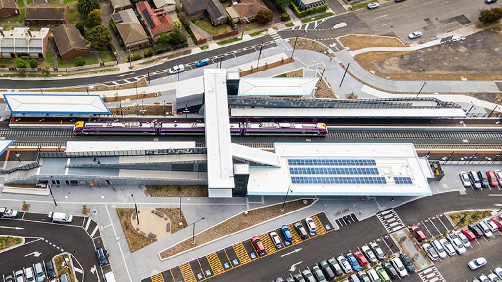 Aerial view of train station with landscaping, walkways and a car park