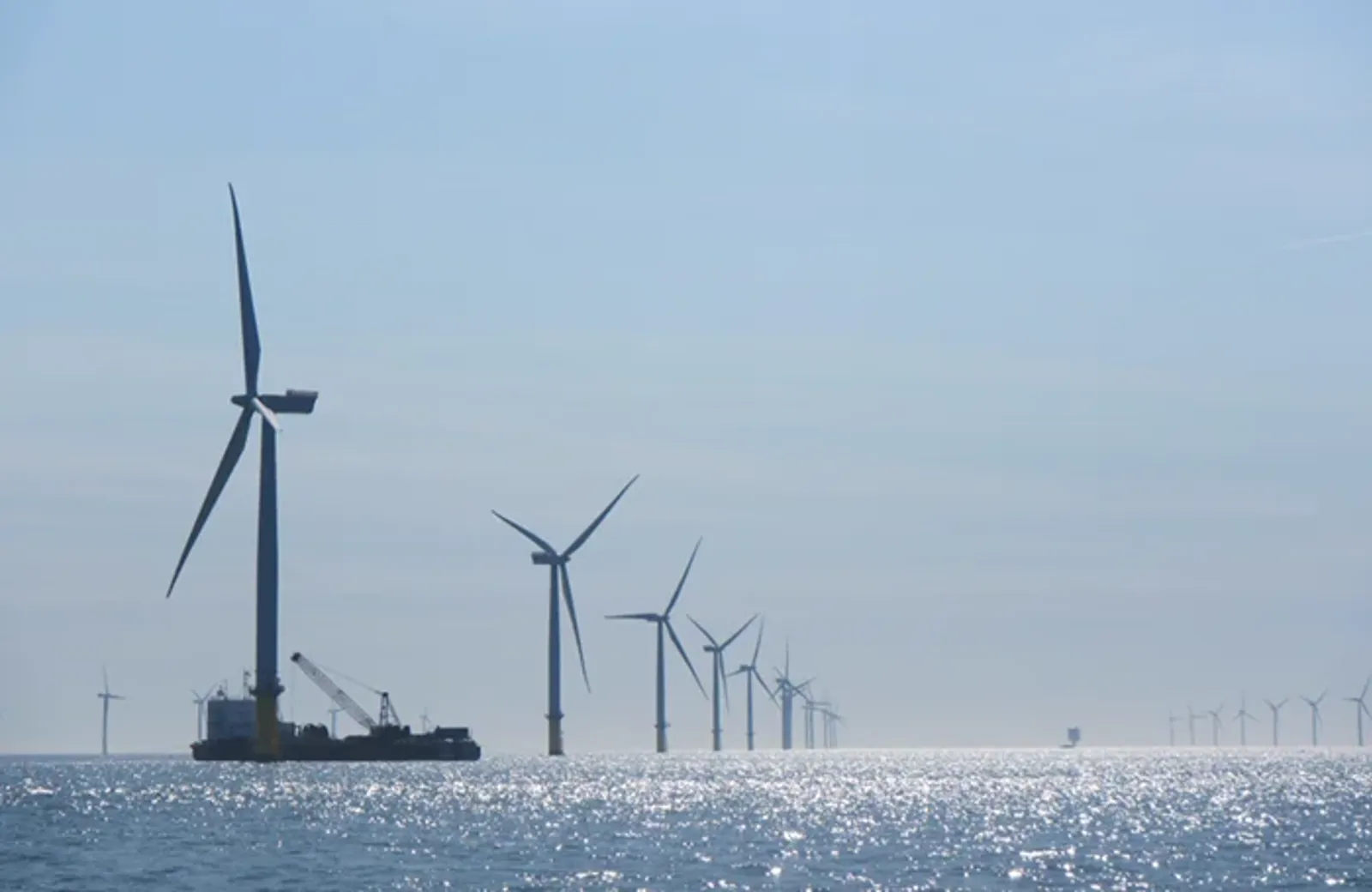 A group of wind turbines in the water.