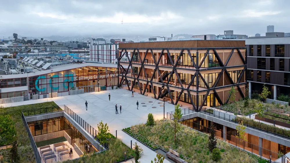 A large building with a courtyard and people walking around.