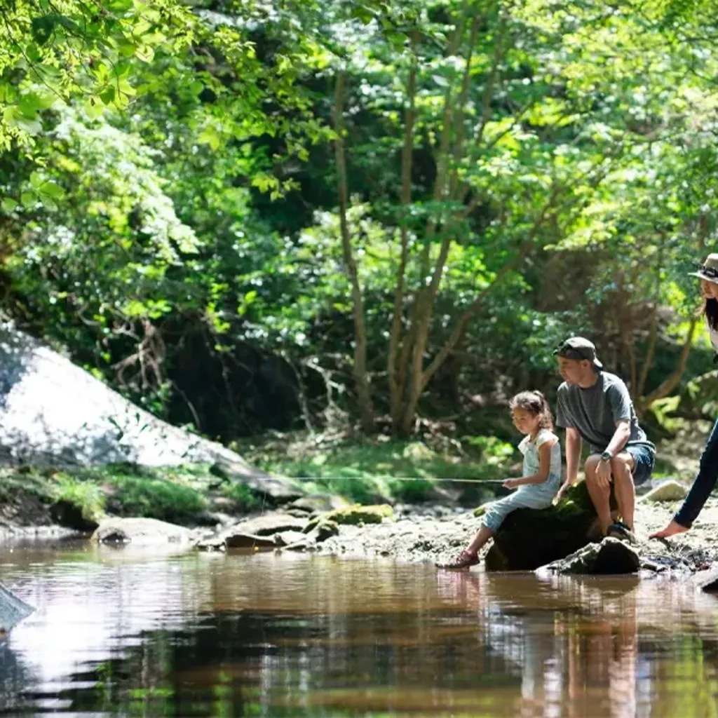 A group of people sitting on a log in a river.