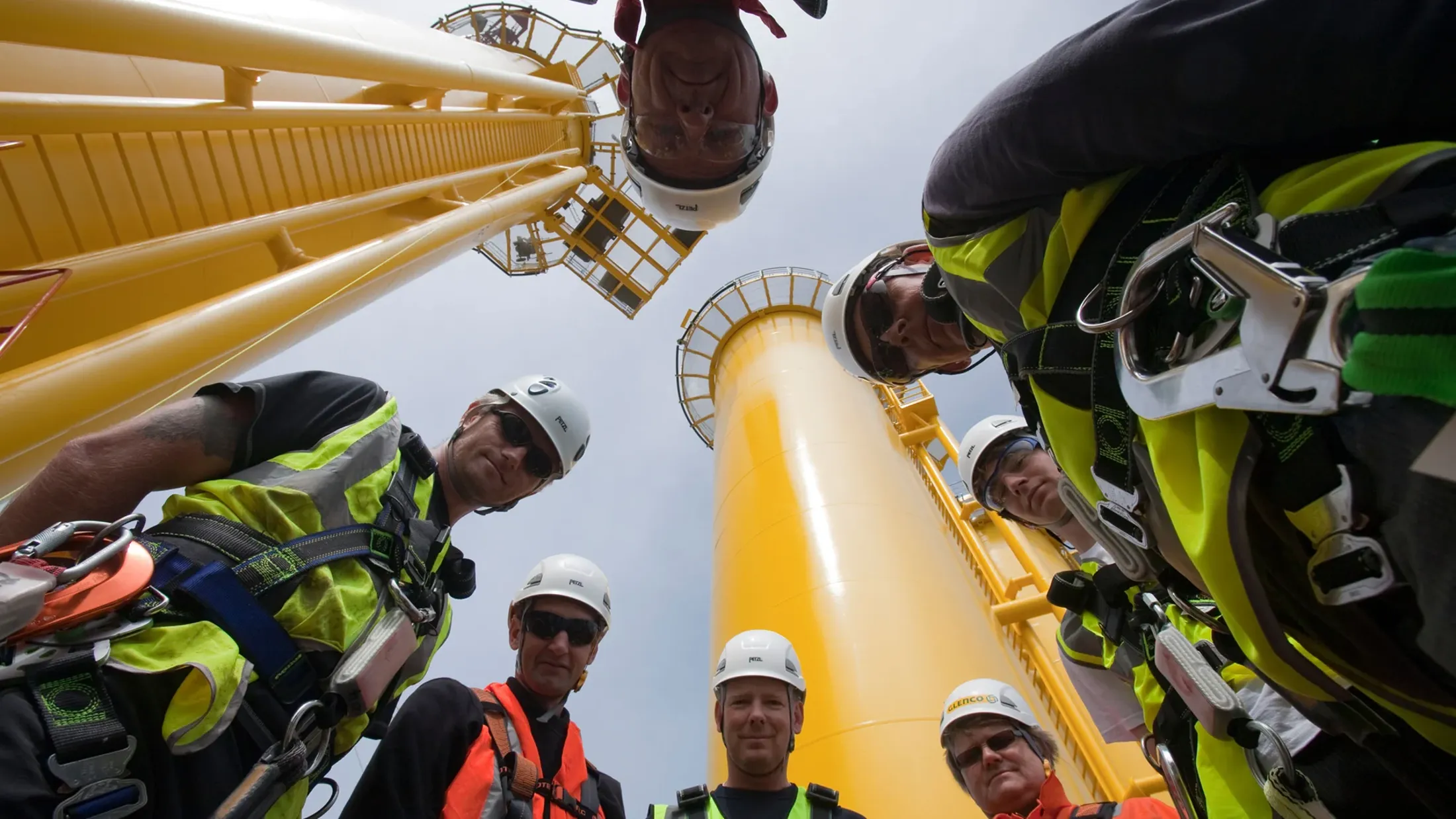 A group of people in hardhats and helmets on a boat.