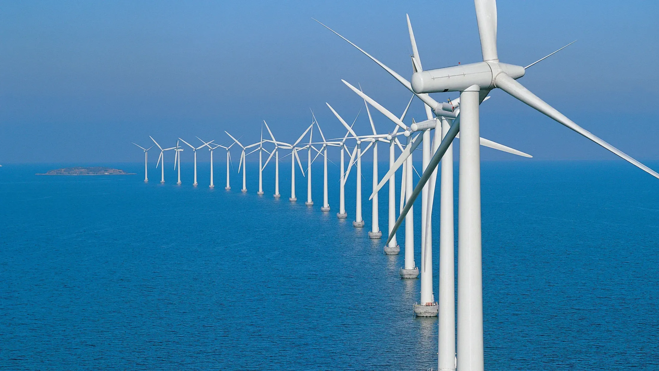 A group of wind turbines in the ocean.