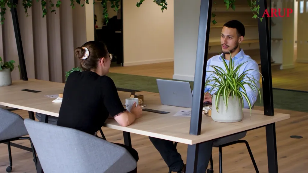 A man and a woman sitting at a table with a laptop.